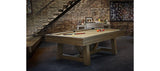 Brunswick Billiards Botanic 8' Pool Table with balls and cues in a rustic game room.