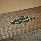Close-up of a Brunswick Billiards logo plaque on the Botanic 8' Pool Table.
