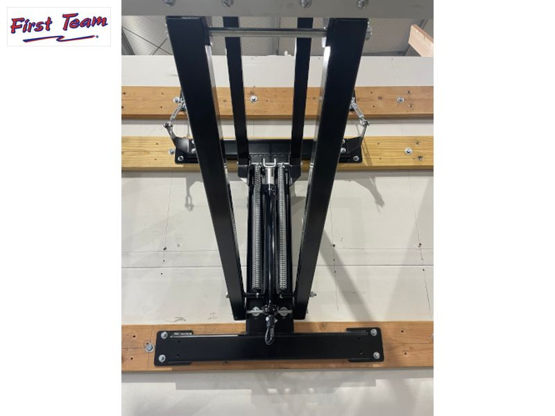 Black metal stand on a wooden platform with 'First Team' branding.