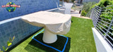 A mushroom-shaped table is near a Kettler FAS Ciclope White Outdoor Foosball Table on turf and blue tiles.