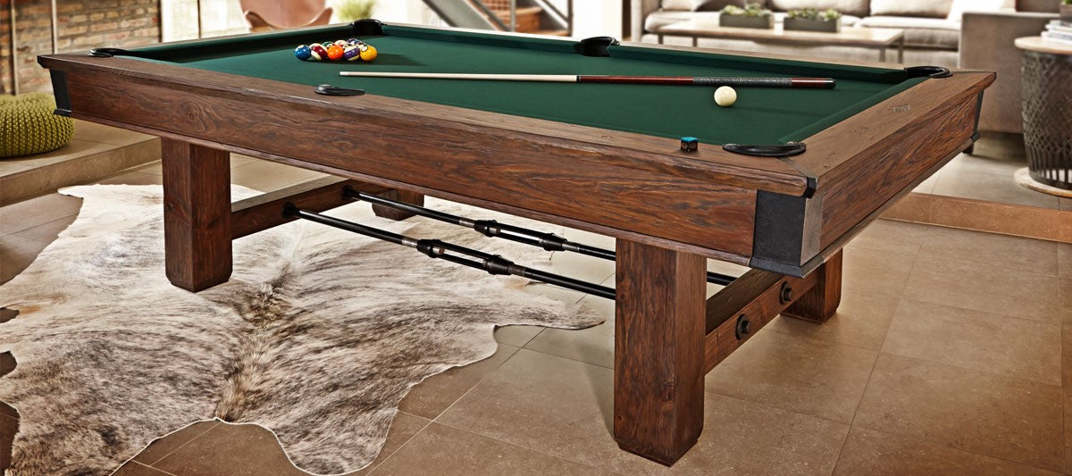 The Brunswick Billiards Canton 7' Pool Table in Black Forest on a tiled floor with balls and cues.