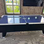 A Dynamo 8' Pro Style Air Hockey Table in a room with large windows.