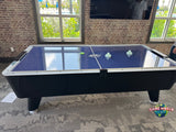 A Dynamo 8' Pro Style Air Hockey Table in a room with large windows.
