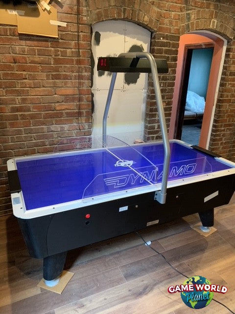Dynamo 8' Pro Style Home Air Hockey Table with electronic scorekeeper in brick-walled room.