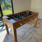Venture Wooden foosball table in a room with a window and carpeted floor.