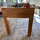 Venture Wooden foosball table in a room with big windows and carpeted floor.