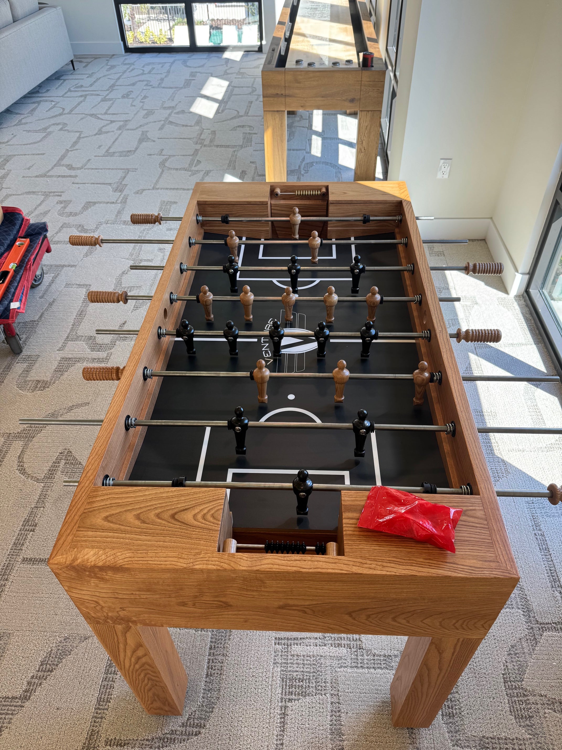 Venture Buckhead Foosball Table in a room with large windows.