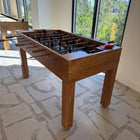 Wooden Venture table with a modern interior design featuring large windows and patterned wallpaper.