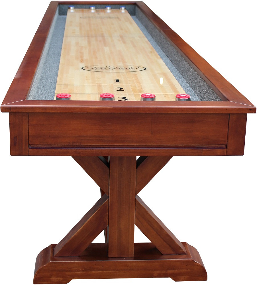 Wooden shuffleboard table with red pucks on a white background
