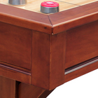 Close-up of a wooden pool table with a red and silver pool cue holder.