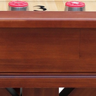 Wooden shuffleboard table with red pucks on a white background