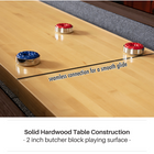 Wooden shuffleboard table with red and blue pucks on a gray floor.