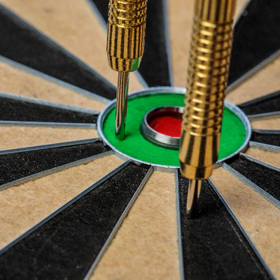 Two gold darts hitting a target with a bullseye.