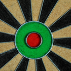 Close-up of a dartboard with concentric circles in green, red, and black.
