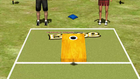Incredible Technologies Arcade Collection Kit beside cornhole on grass, two players’ legs visible.