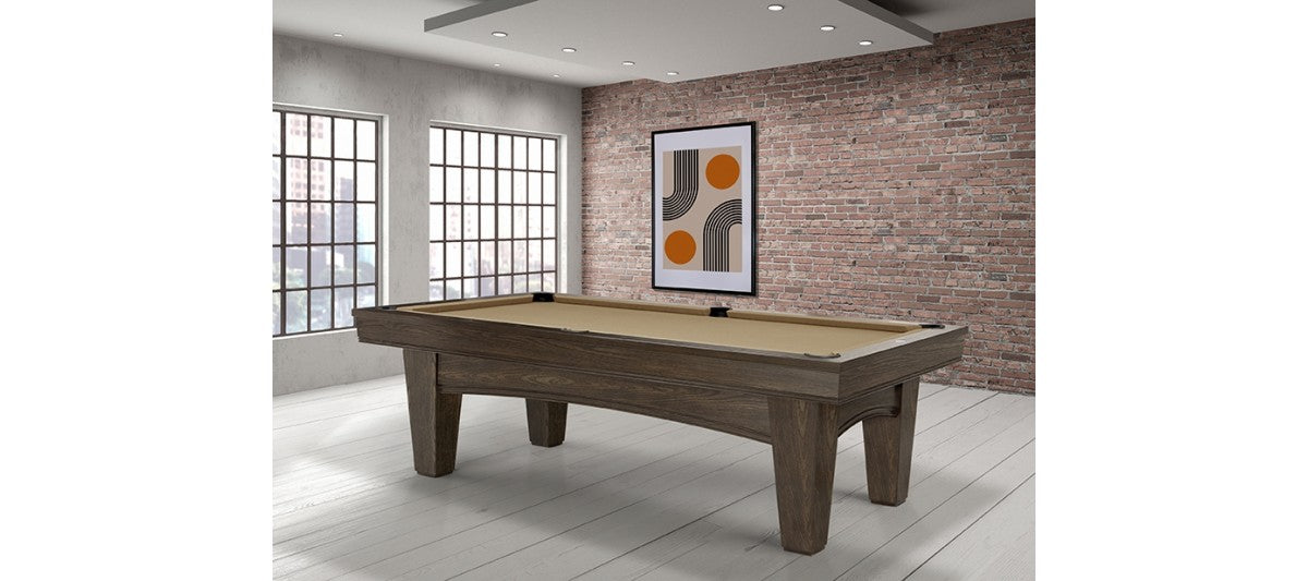 A Brunswick Billiards Winfield 8' Pool Table stands in a modern room with brick walls and windows.