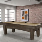 A Brunswick Billiards Winfield 8' Pool Table stands in a modern room with brick walls and windows.