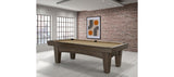 A Brunswick Billiards Winfield 8' Pool Table stands in a modern room with brick walls and windows.