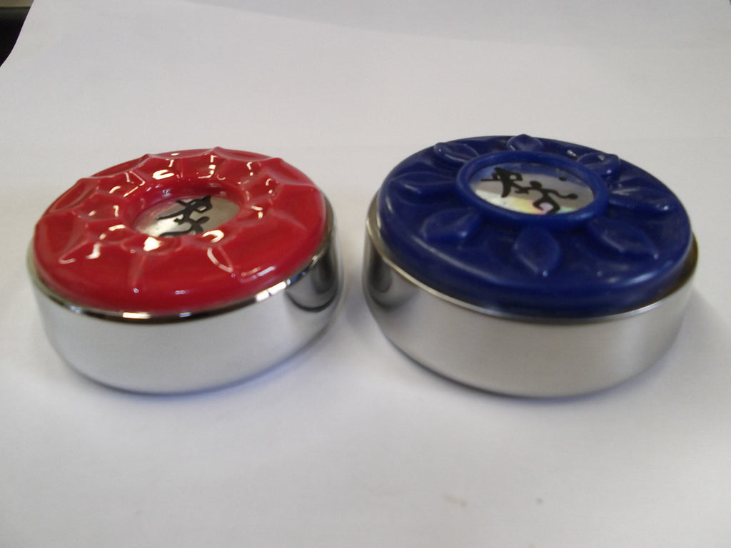 Two Playcraft shuffleboard weights, red and blue tops, on a white surface.