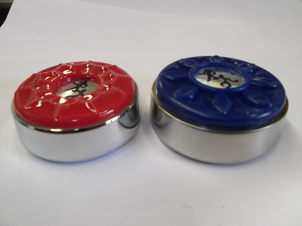 Two Playcraft shuffleboard weights—red and blue tops, each with a stick figure logo.
