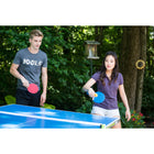 Two people playing outdoor table tennis with the JOOLA Linus Outdoor Table Tennis Racket.