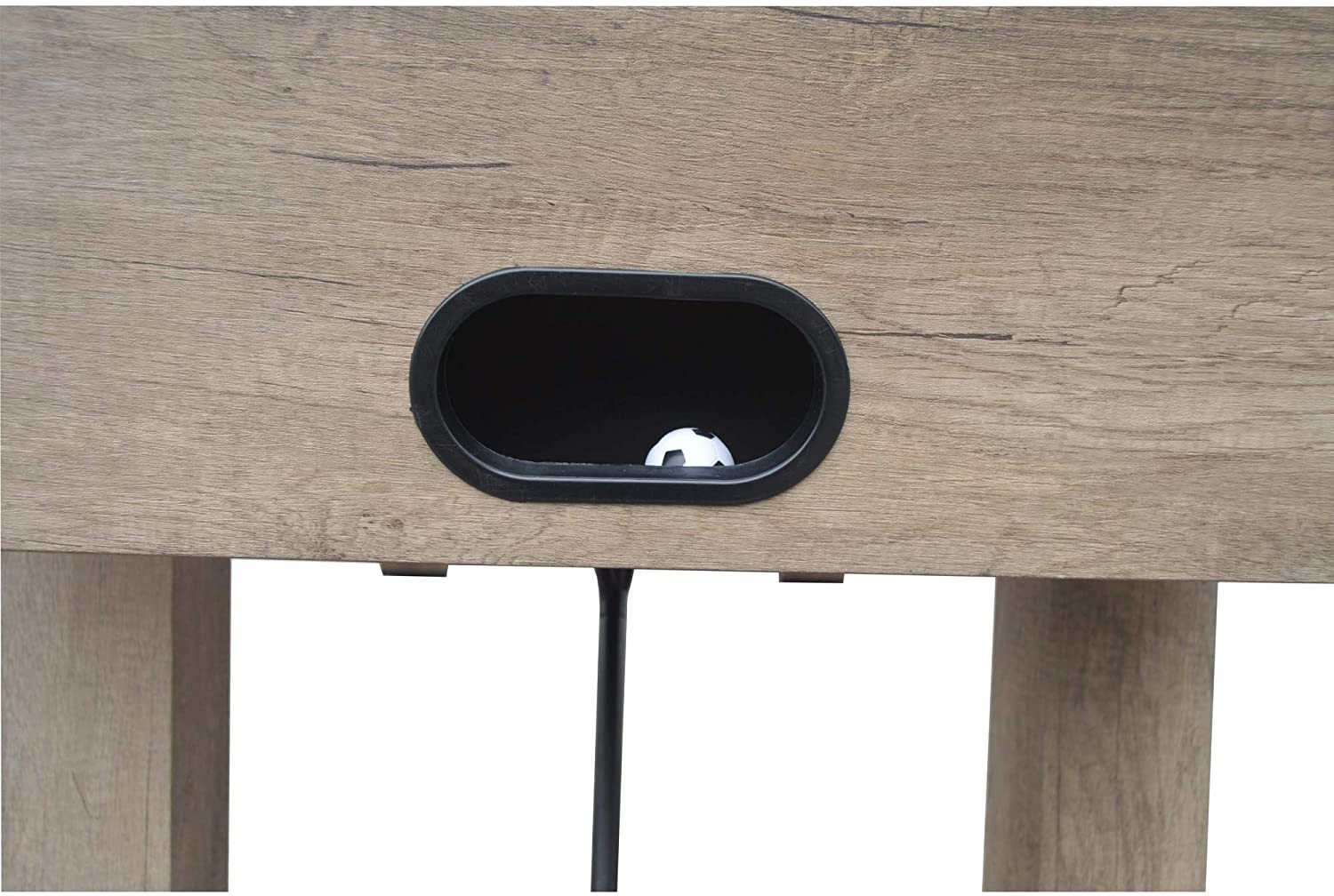Close-up of the ball return slot on the Hathaway Braxton 55'' Foosball Table with a ball inside.