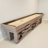 The Champion Rustic 9' Shuffleboard Table by Champion stands against a plain wall on carpet.