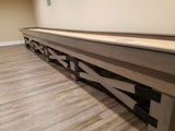 Champion Rustic 9' Shuffleboard Table by Champion stands on wood-patterned flooring.