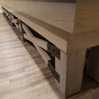 Wooden bench with metal brackets beside Champion Rustic 9' Shuffleboard Table on wood floor.