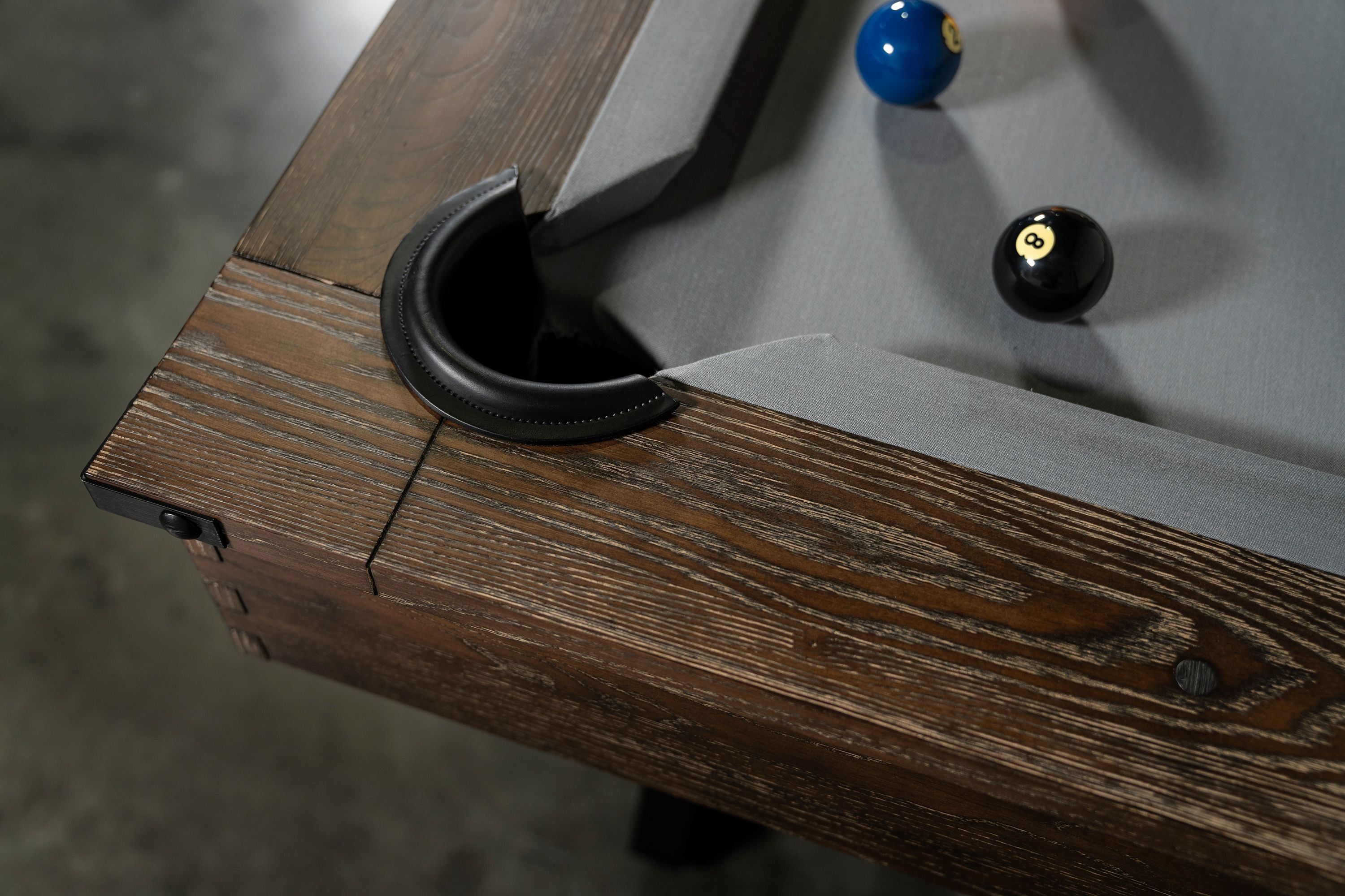 Corner of Nixon Hunter 7' Slate Pool Table in Brushed Walnut by Nixon Billiards with gray felt.