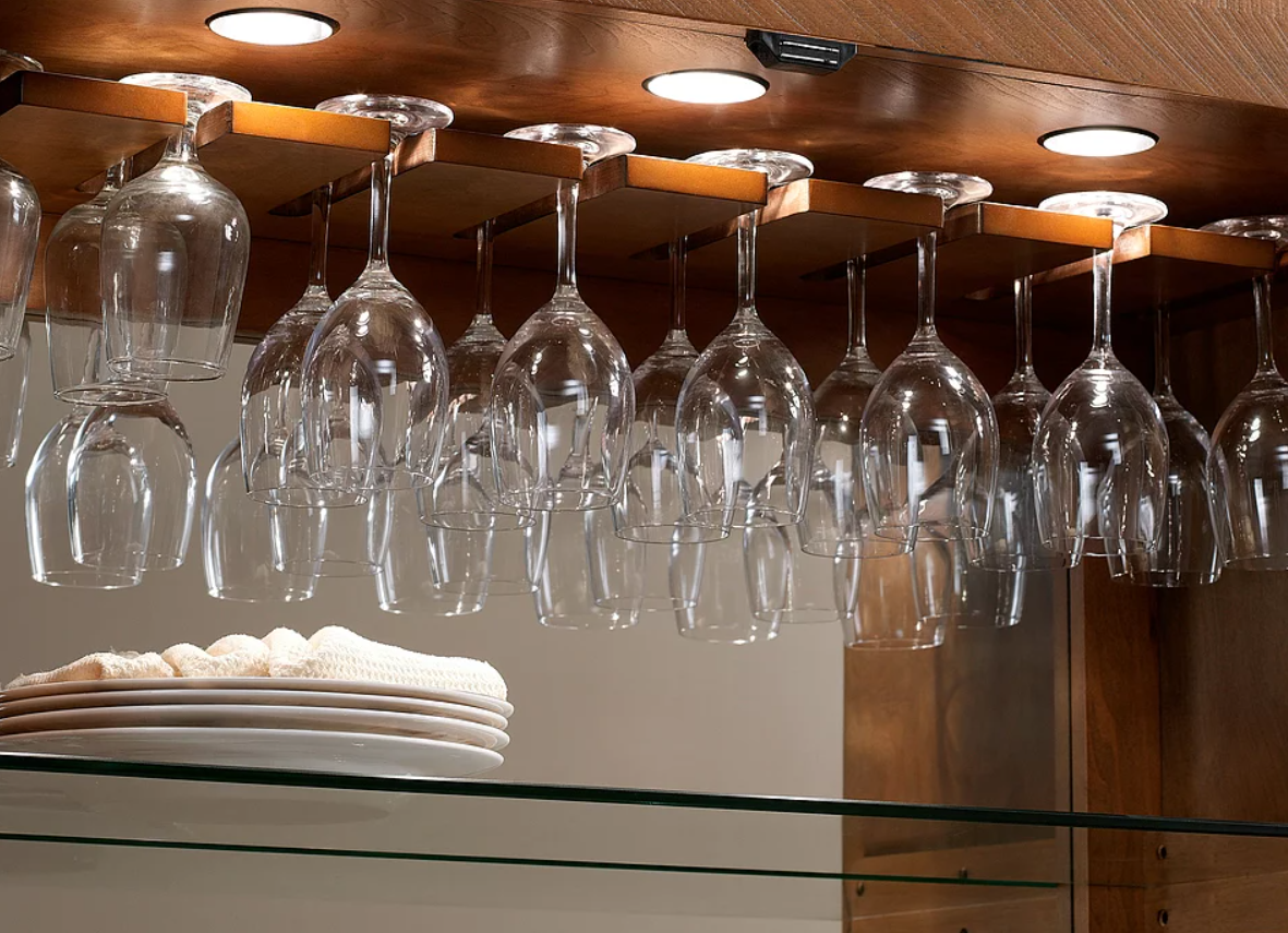 Wine glasses hang above stacked plates in the American Heritage Billiards Braxton Cabinet.