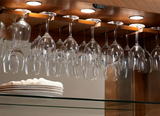 Wine glasses hang above stacked plates in the American Heritage Billiards Braxton Cabinet.
