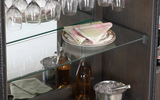 Glassware, plates, and bottles are displayed in the American Heritage Billiards Fairfield Wine Cabinet.