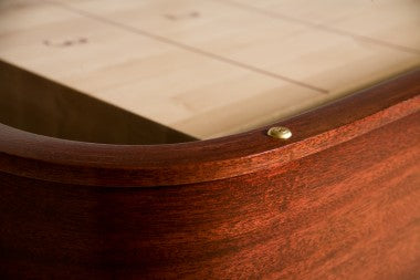 Close-up of Venture Grand Deluxe 18' Shuffleboard Table corner with brass screw and light wood.