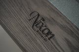 Close-up of a Nixon Birdy 7' Slate Pool Table in Grayson Grey’s wooden surface with engraved logo.