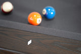 Three balls rest on a Nixon KAI 7' Slate Pool Table in Waxed Brown by Nixon Billiards.