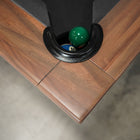 Close-up of Nixon KAI 8' Slate Pool Table by Nixon Billiards in walnut finish on concrete floor.