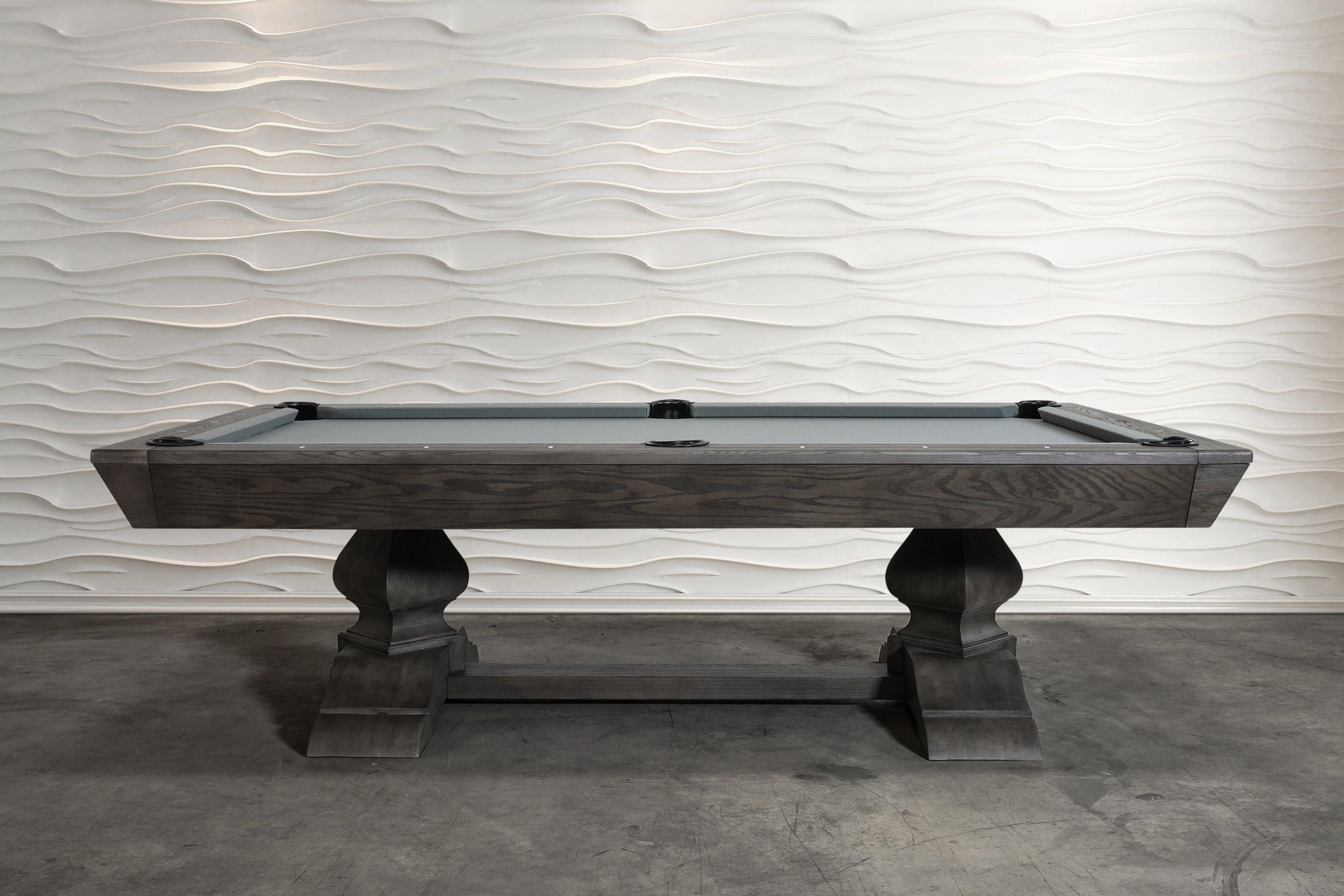Nixon Birdy 8' Slate Pool Table in Grayson Grey by Nixon Billiards before a wavy white wall.
