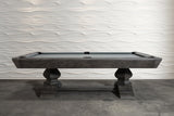 Nixon Birdy 8' Slate Pool Table in Grayson Grey by Nixon Billiards before a wavy white wall.