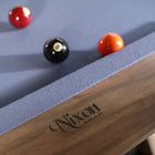 Three billiard balls on a Nixon Desyn 8' Walnut Pool Table by Nixon Billiards.