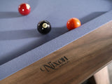 Three billiard balls on a Nixon Desyn 8' Walnut Pool Table by Nixon Billiards.