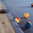 Three billiard balls rest near a pocket on a Nixon Huck 7' Slate Pool Table in Grey White Oak.