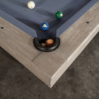 Corner of a Nixon Huck 7' Slate Pool Table in Grey White Oak by Nixon Billiards, balls in pocket.
