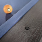 A yellow 9-ball sits on a Nixon Kemp 8' Slate Pool Table by Nixon Billiards in Grayson Grey.