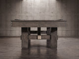 The Nixon Kemp 8' Slate Pool Table by Nixon Billiards adds charm to the modern concrete room.