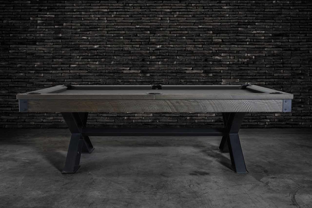 The Nixon Portland 8' Barnwood Pool Table by Nixon Billiards stands before a dark brick wall.