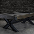 Nixon Billiards Portland 8' Barnwood Pool Table with black legs, set by a brick wall.