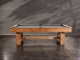 The Nixon Presli 7' Slate Pool Table in Native Acacia finish sits on a concrete floor.