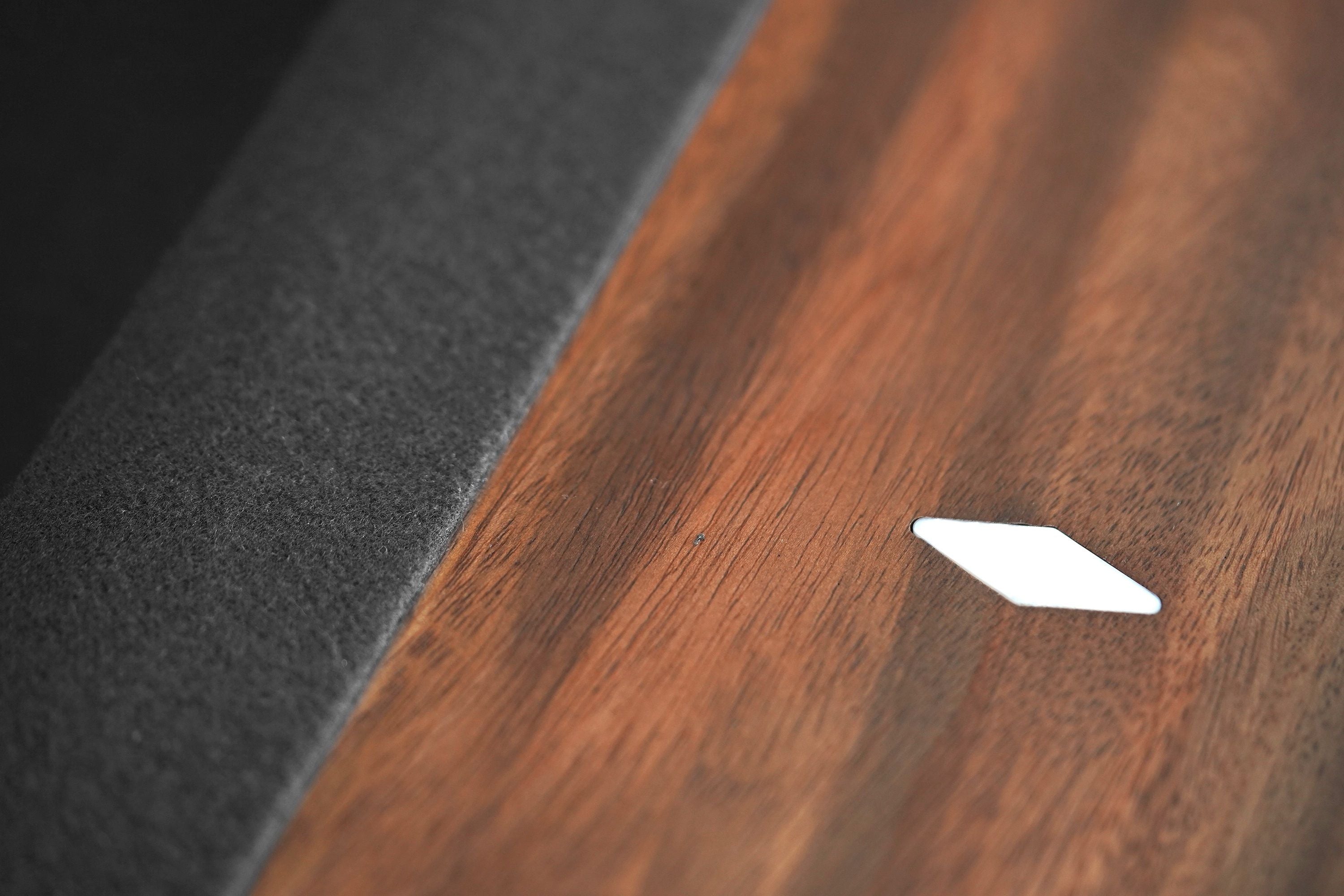 Close-up of Nixon KAI 8' Slate Pool Table’s walnut surface with white diamond inlay by Nixon Billiards.