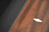 Close-up of Nixon KAI 8' Slate Pool Table’s walnut surface with white diamond inlay by Nixon Billiards.